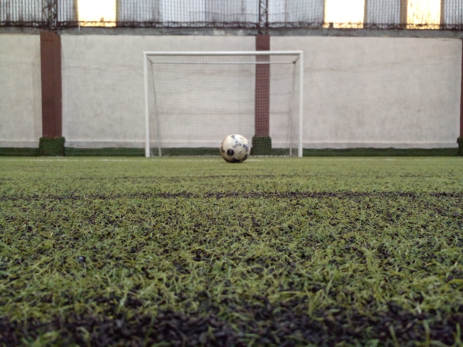 Balón frente a una portería en el campo de entrenamiento