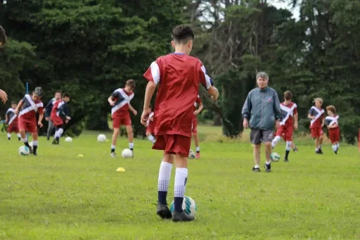Facundo Alvanezzi acompañando a un joven futbolista durante un ejercicio
